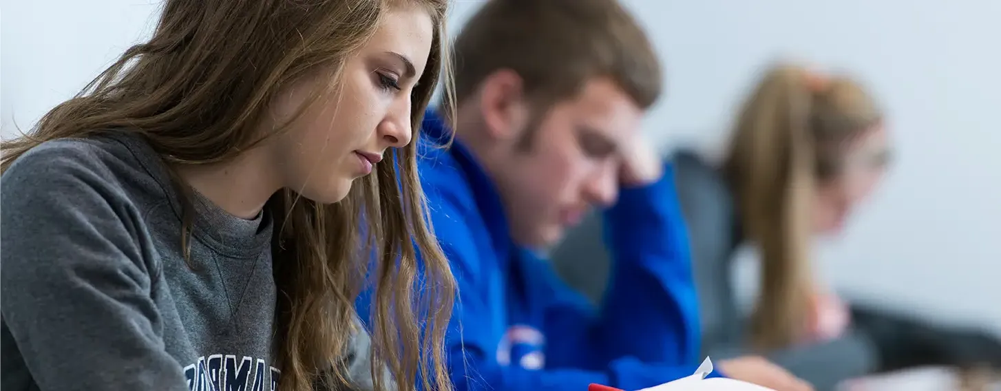 Students reviewing papers in a classroom.